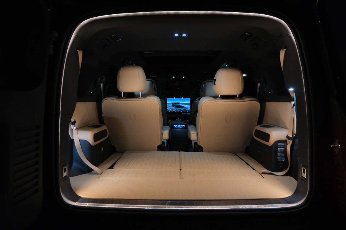 Denza B8 boot opening illuminated by BAOLAB hidden perimeter boot light, showing a continuous soft white glow around the cargo opening at night.