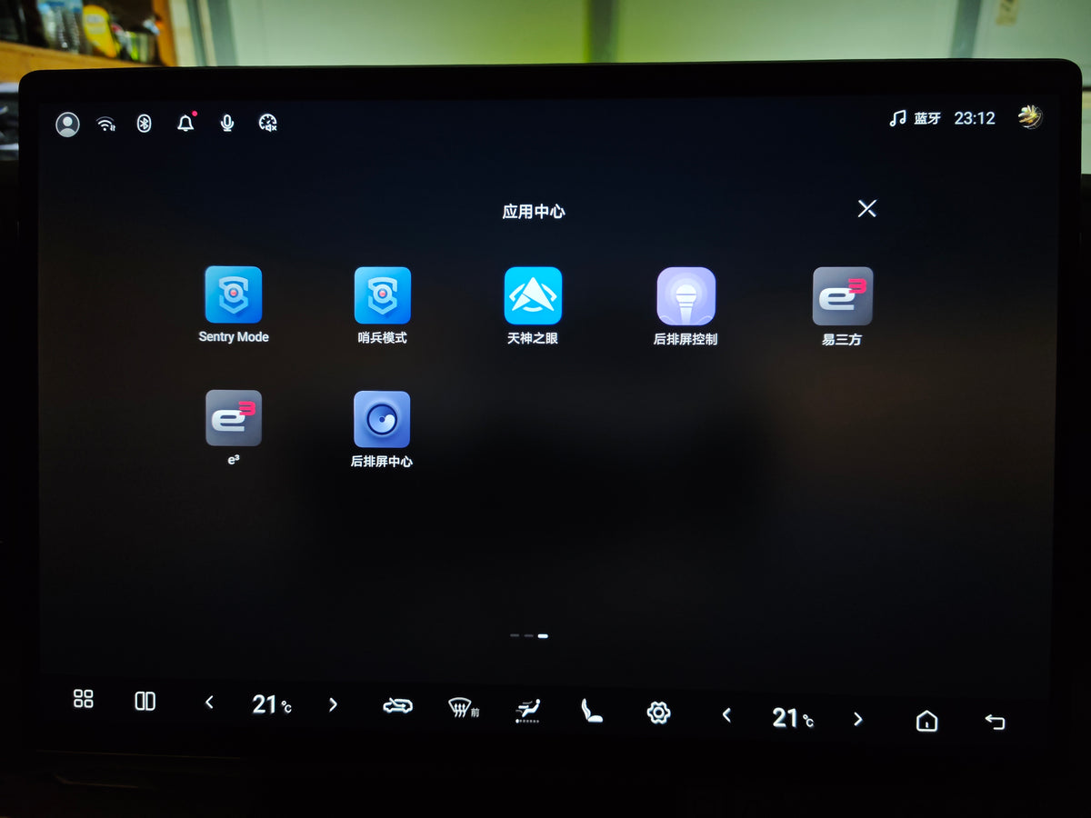 A close-up of a large touchscreen display showing a dark car infotainment or vehicle control interface with multiple app icons and Chinese text labels.