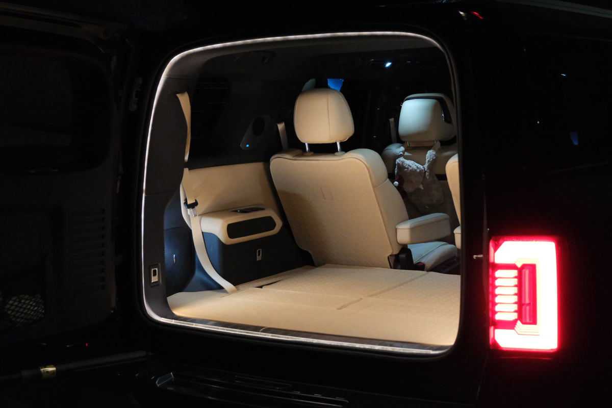 Angled rear view of the Denza B8 boot with BAOLAB hidden perimeter boot light installed, showing the illuminated cargo opening at night.