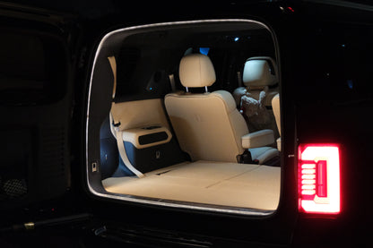Angled rear view of the Denza B8 boot with BAOLAB hidden perimeter boot light installed, showing the illuminated cargo opening at night.