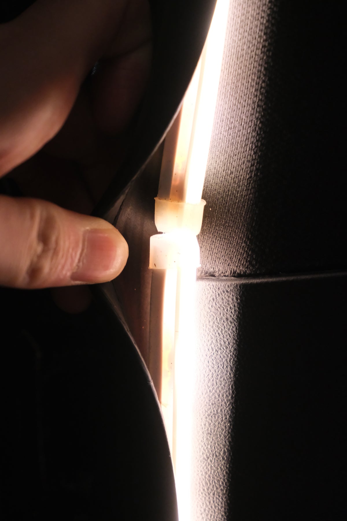 Close-up of the BAOLAB hidden perimeter boot light tucked behind the Denza B8 boot weather seal, showing the discreet hidden installation.